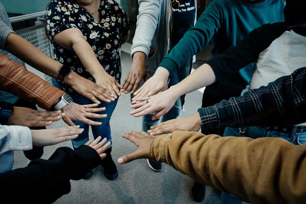 diverse-group-of-hands-huddled-together-teamwork